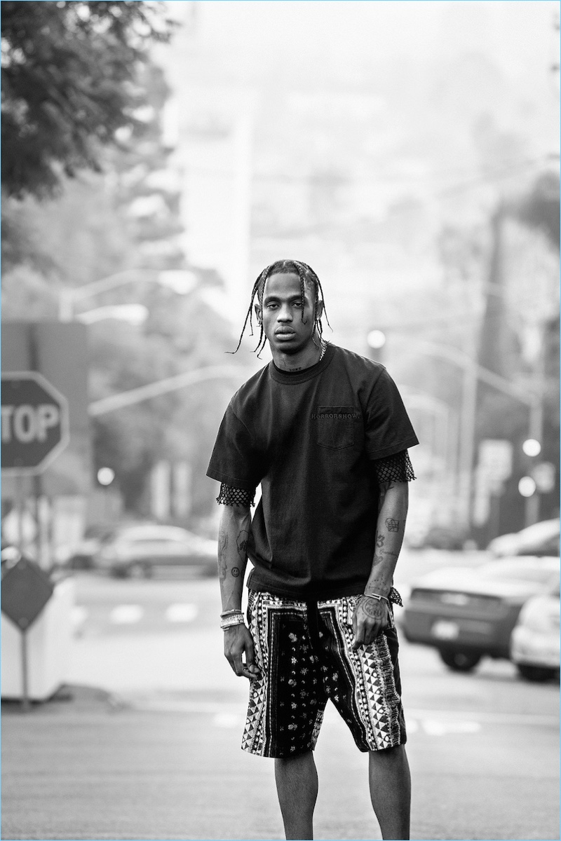 Taking to the streets of California, Travis Scott wears a pocket tee, mesh t-shirt, and printed shorts by Sacai.