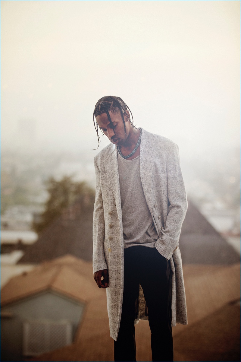 Rapper Travis Scott wears Maison Margiela double-breasted coat with a Bassike tank and Lanvin trousers.