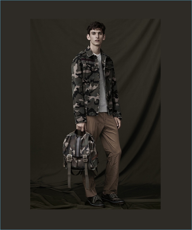 Front and center, Thibaud Charon wears a jacket with a complementary camouflage backpack by Valentino.