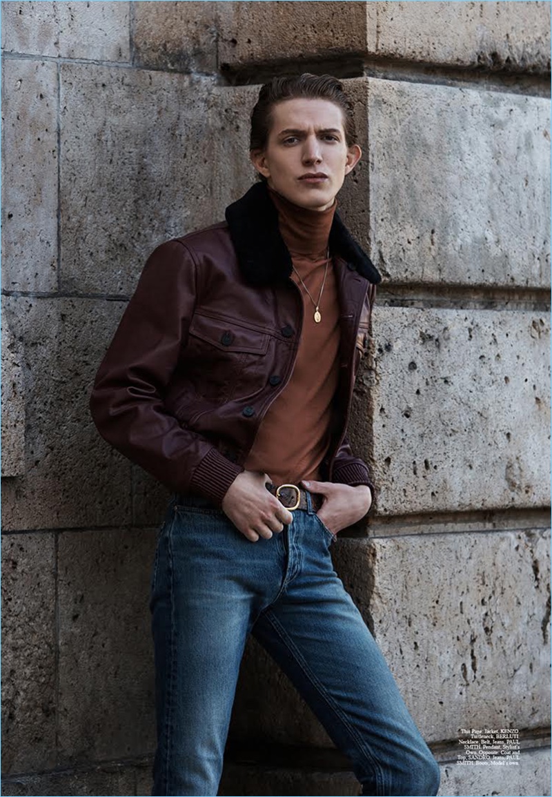 Model Xavier Buestel wears a Kenzo leather jacket with a Berluti turtleneck. The top model also rocks jeans, a leather belt, and necklace by Paul Smith.