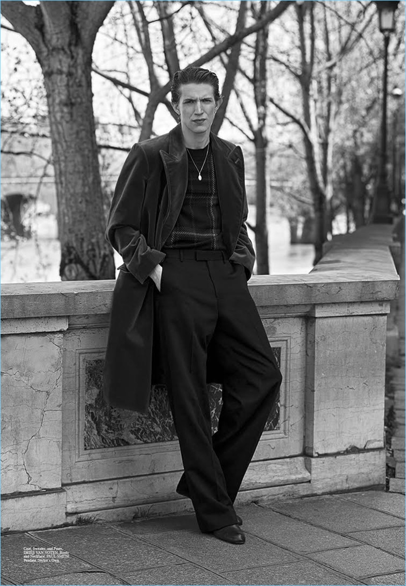 Embracing oversized proportions, Xavier Buestel wears a coat, sweater, and trousers by Dries Van Noten. Xavier also sports boots and a necklace by Paul Smith.