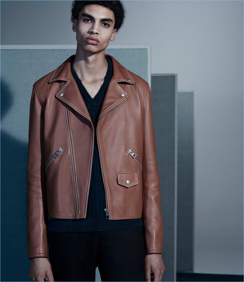 Cool in a leather Loewe jacket, Sol Goss also wears an Inis Meain v-neck sweater and Maison Margiela trousers.