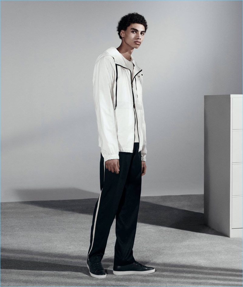 Channeling a sporty attitude, Sol Goss wears a Tomas Maier zip-front anorak with a Vince sweater, Dries Van Noten trousers, and Barneys New York leather sneakers.