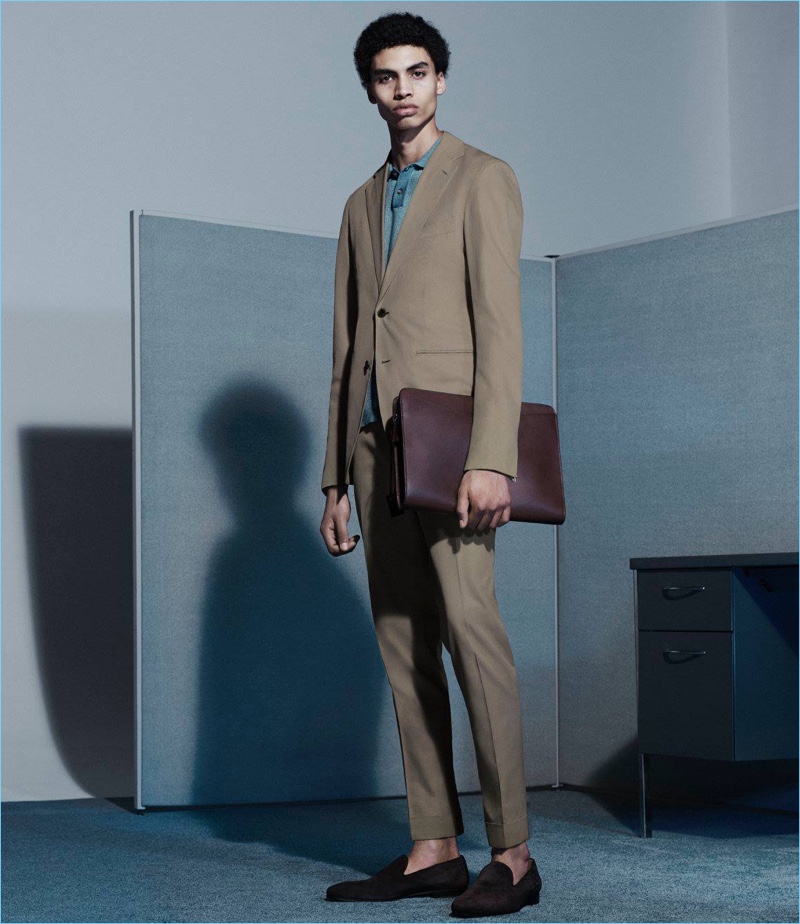 Standing tall, Sol Goss wears a P. Johnson suit with an Orley knit polo, Cifonelli suede Venetian slippers, and a Barneys New York zip-around portfolio.