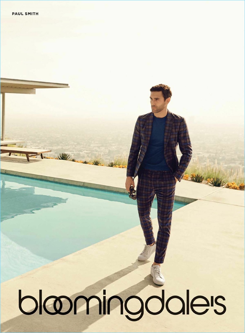 Captured poolside, Noah Mills dons a plaid suit by Paul Smith.