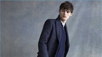 A sleek vision, Alexander Beck dons a Club Monaco denim twill topcoat, floral shirt, slim-fit vintage denim jeans, and a wool zip cardigan.