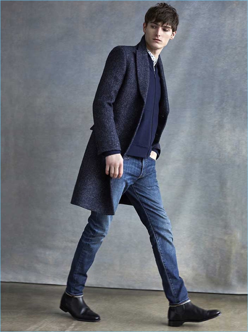 A sleek vision, Alexander Beck dons a Club Monaco denim twill topcoat, floral shirt, slim-fit vintage denim jeans, and a wool zip cardigan.