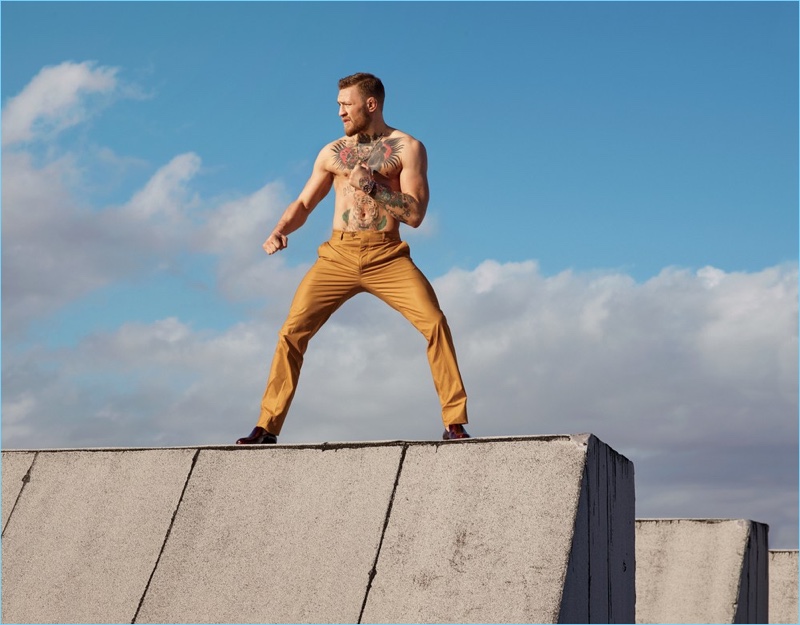 Going shirtless, Conor McGregor strikes a fighting pose in Etro trousers.