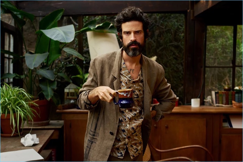 Embracing the style of an artist, Devendra Banhart sports a Valentino camp-collar shirt with trousers and a painted linen overcoat by Isabel Benenato.