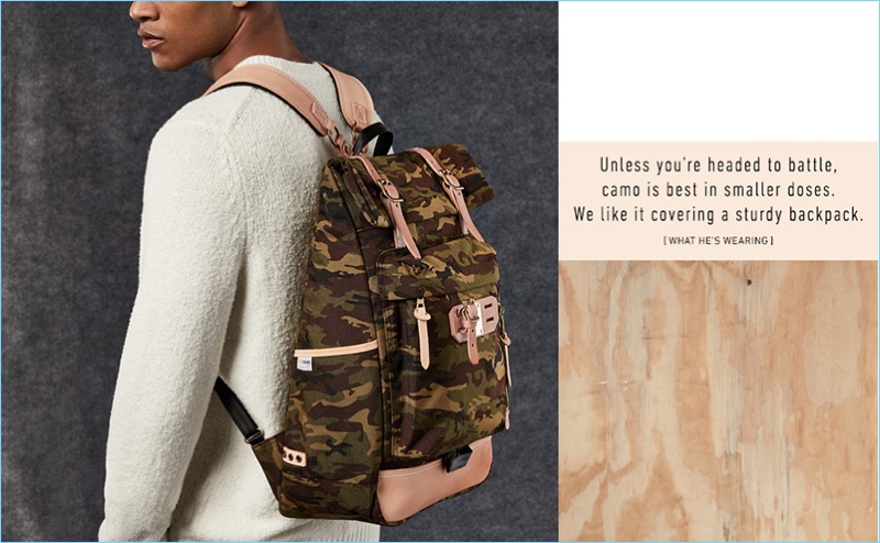 Model Kadeem Fisher rocks a Master-Piece camouflage backpack with a Vince sweater.