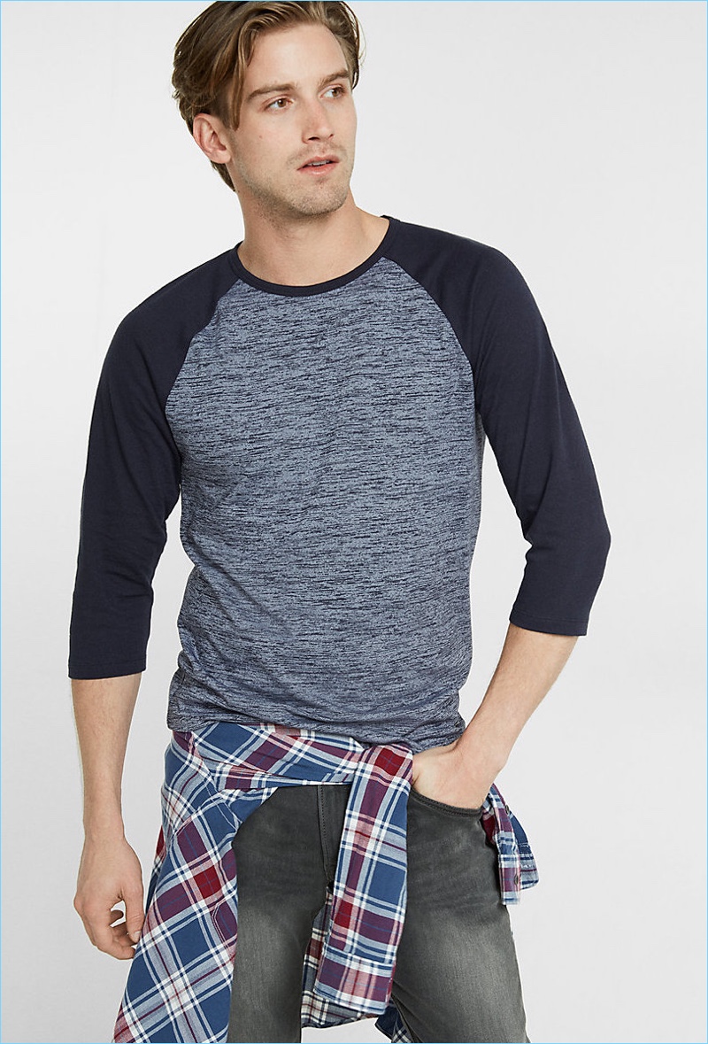 RJ King sports a heathered baseball tee from Express with distressed denim jeans and a plaid shirt.