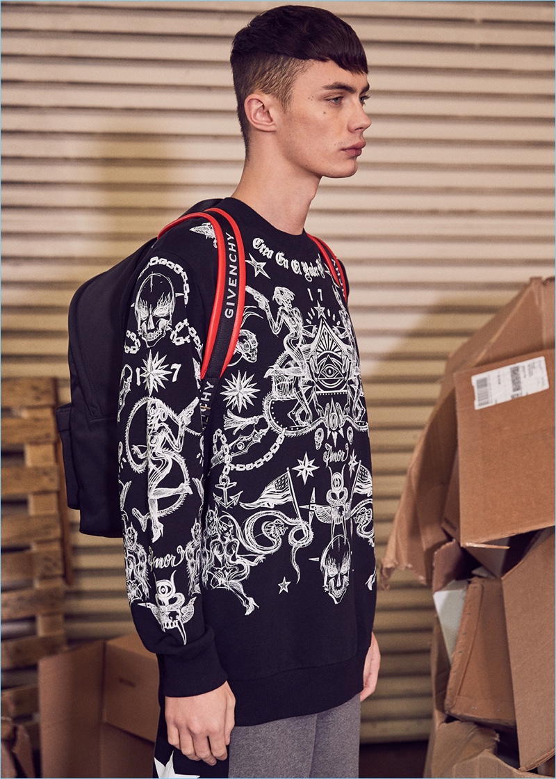 The high fashion rebel, Simon Kotyk wears an all-over tattoo print sweatshirt, shorts, and a backpack by Givenchy.