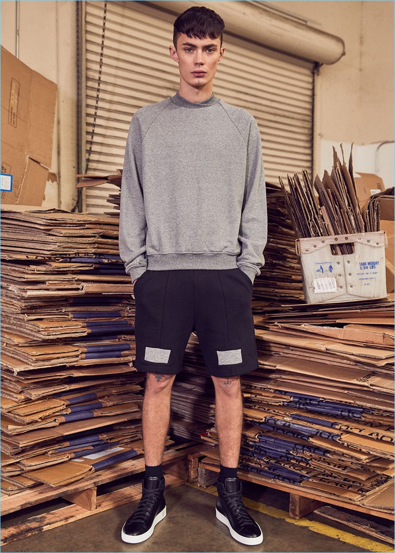 Making a sporty statement, Simon Kotyk wears a sweatshirt, shorts, and sneakers by John Elliott.