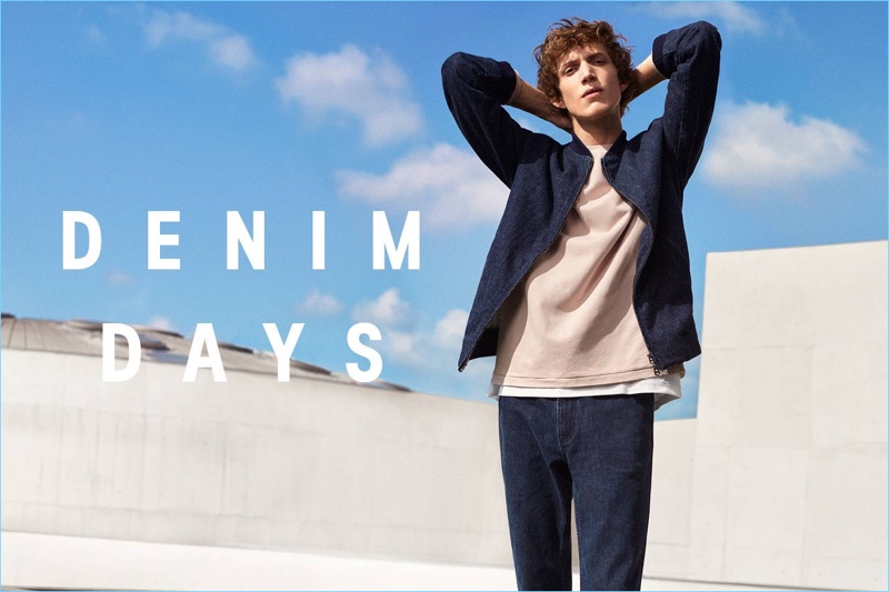 Xavier Buestel wears a denim bomber jacket, wide-cut sweatshirt, cotton piqué t-shirt, and jeans from H&M.