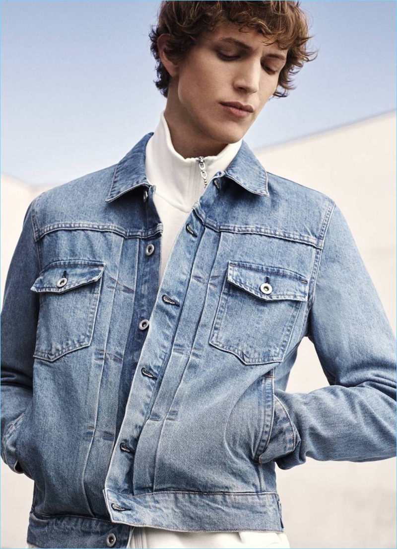 Model Xavier Buestel sports a denim jacket and full-zip cardigan from H&M.