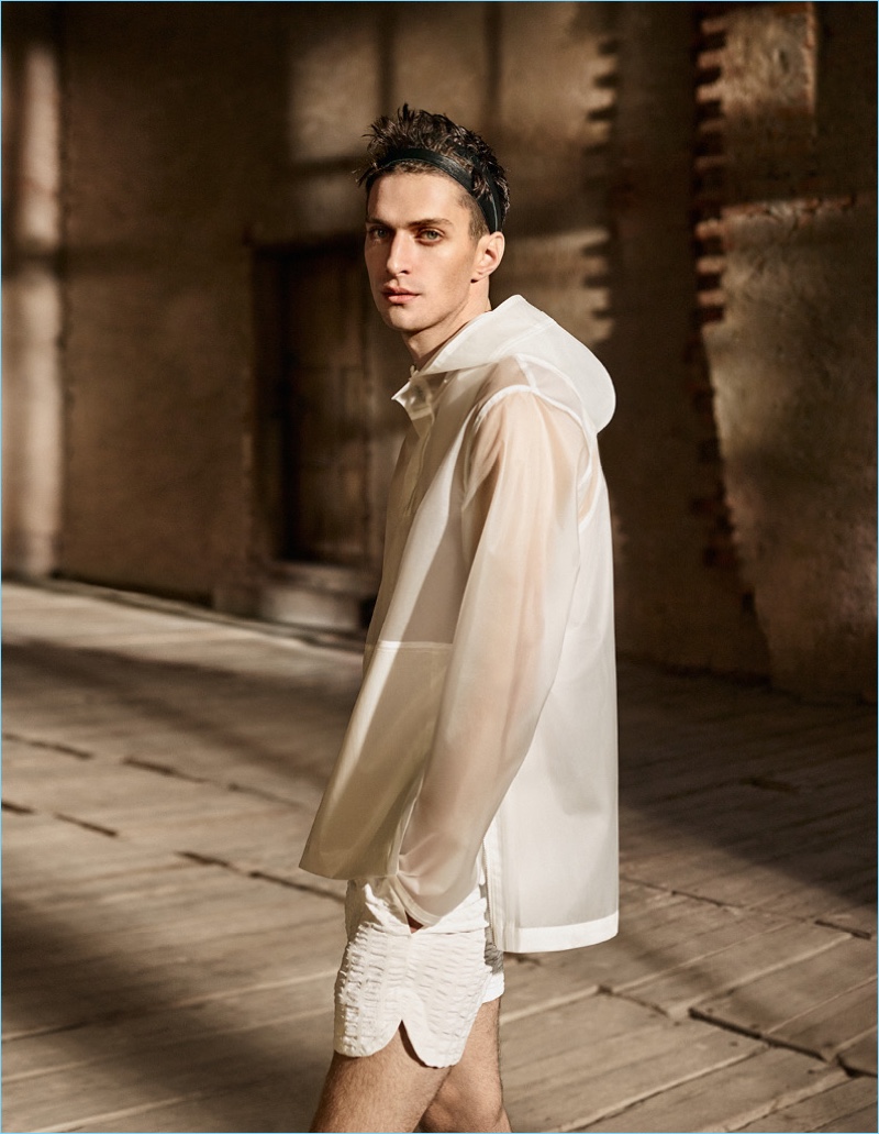 Making quite the style statement, Matthew Bell wears a white raincoat and shorts from H&M Studio.