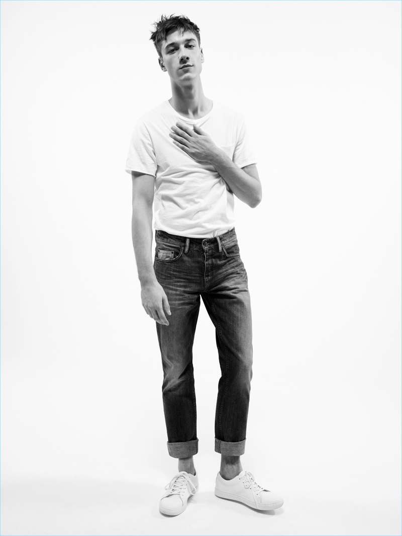Model Harvey James rocks a classic tee with distressed denim jeans and white sneakers for Mango Man's spring-summer 2017 denim campaign.