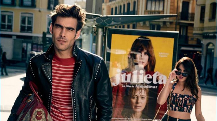 Jon Kortajarena wears a Dsquared2 jacket, belt, and denim jeans. Holding a Gucci bag, the Spanish model also wears a Sandro sweater and Converse sneakers.