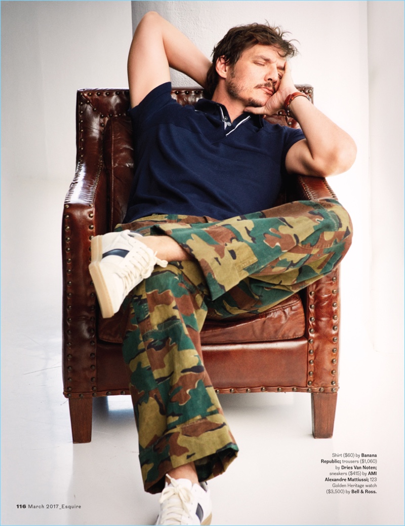 Relaxing, Pedro Pascal wears a Banana Republic shirt with Dries Van Noten camouflage pants, and Ami sneakers.