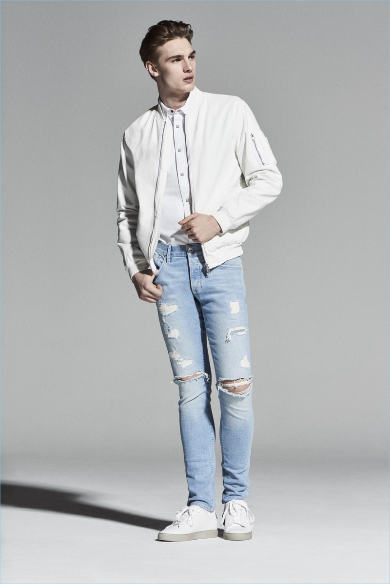 Tommy Marr wears ripped light wash denim jeans by River Island.