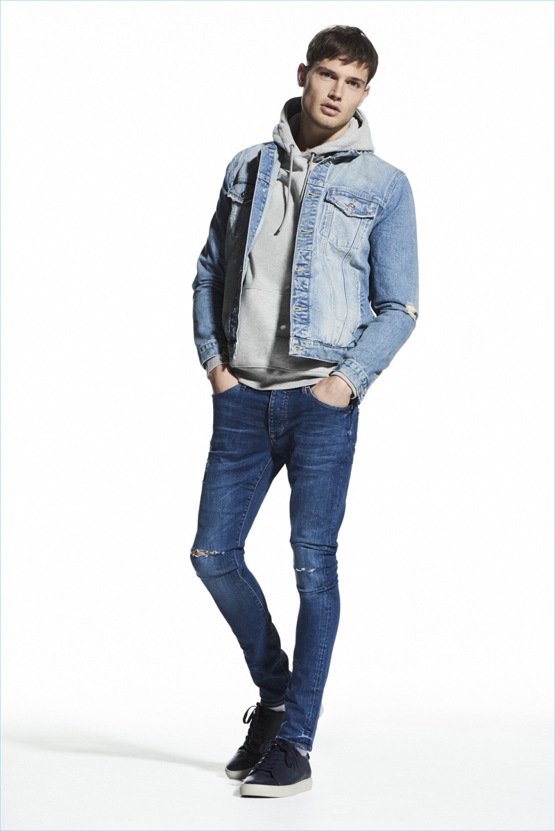 Channeling 90s style, Stefan Pollmann layers a hoodie with a denim jacket from River Island.