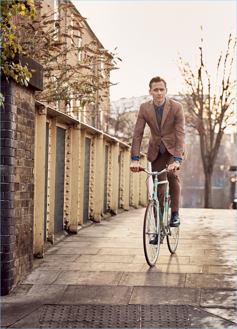 Taking a bike ride, Tom Hiddleston wears an Ermenegildo Zegna suit, shirt and tie with To Boot New York shoes.