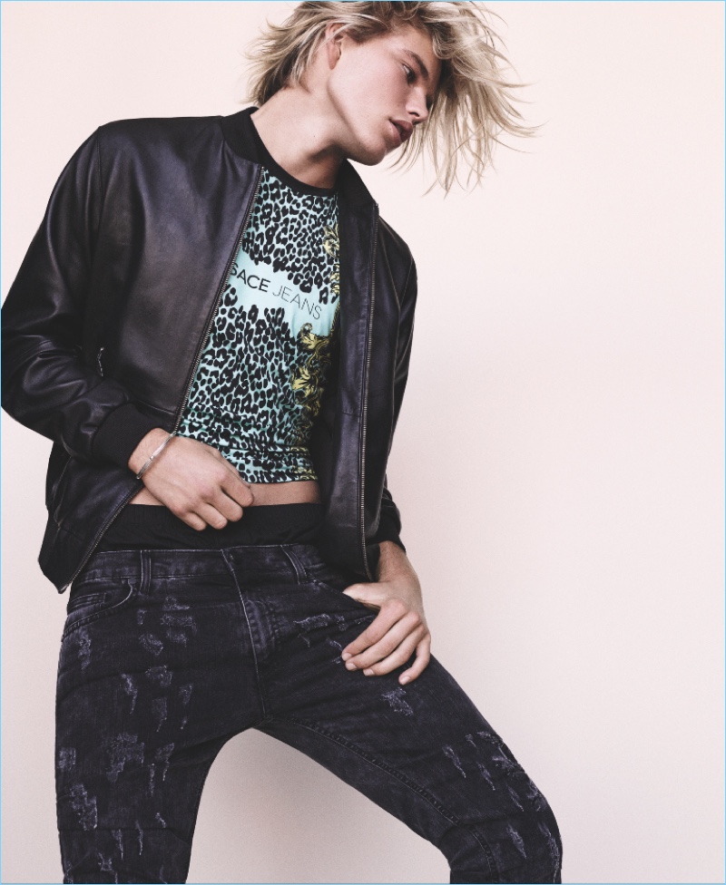 Appearing in Versace Jeans’ spring-summer 2017 lookbook, Jordan Barrett wears a leather bomber jacket with printed jeans.