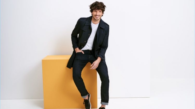 All smiles, Andres Velencoso wears a trench coat with jeans and an easy tee from Esprit.