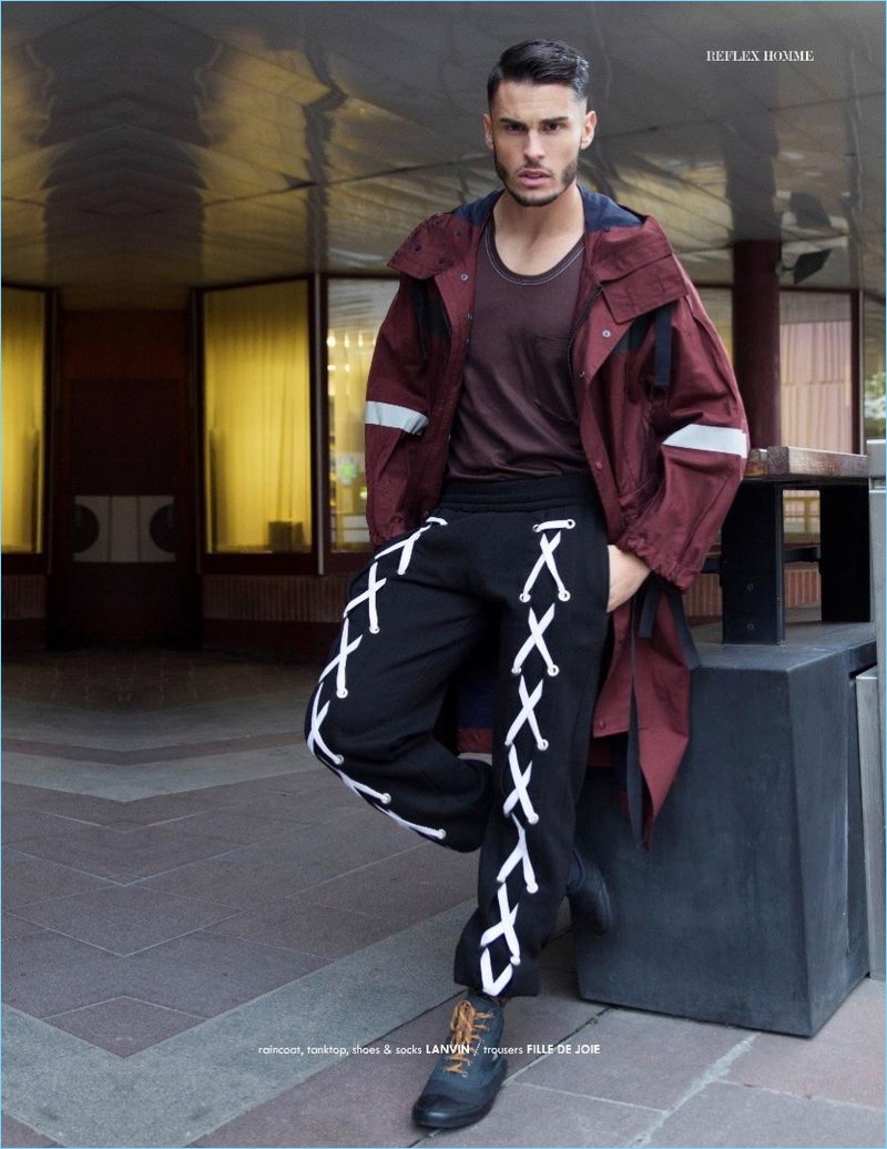 Starring in an editorial for Reflex Homme, Baptiste Giabiconi wears Fille de Joie joggers with a raincoat, tank, and shoes by Lanvin.