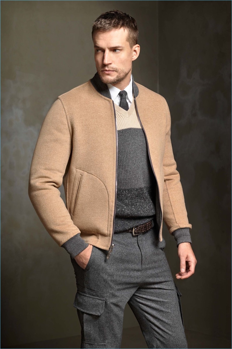 The bomber jacket receives a preppy update as Brunello Cucinelli styles a tan version with a ribbed sweater and grey cargo pants.