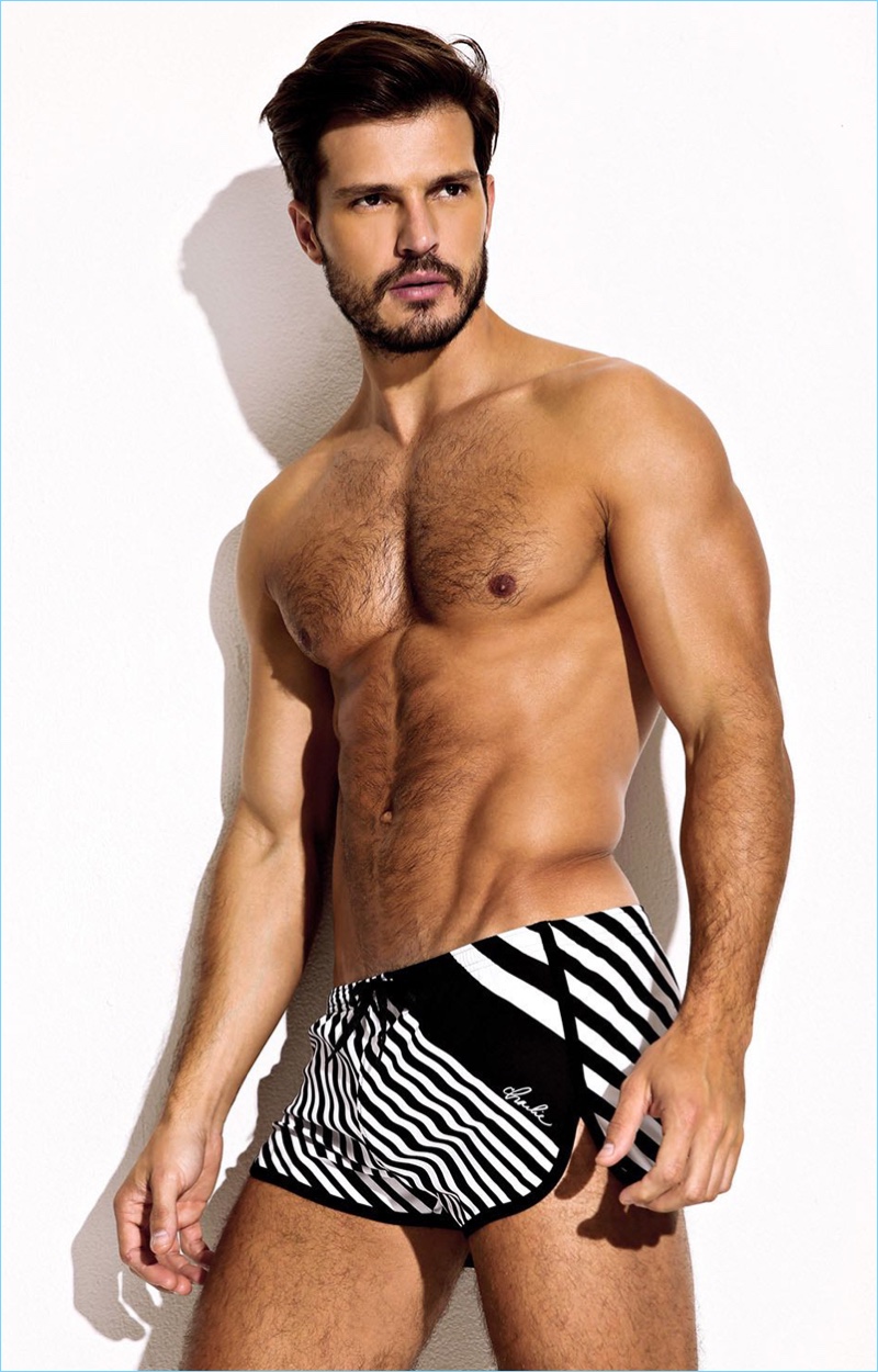 Model Diego Miguel wears Charlie by Matthew Zink's Black Magnum Stripe Trainer swim shorts.