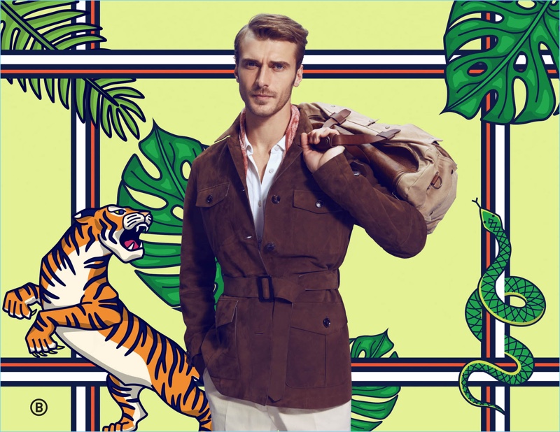 Safari chic, Clément Chabernaud wears a field jacket look by Ermenegildo Zegna. The French model also takes hold of a Belstaff bag.