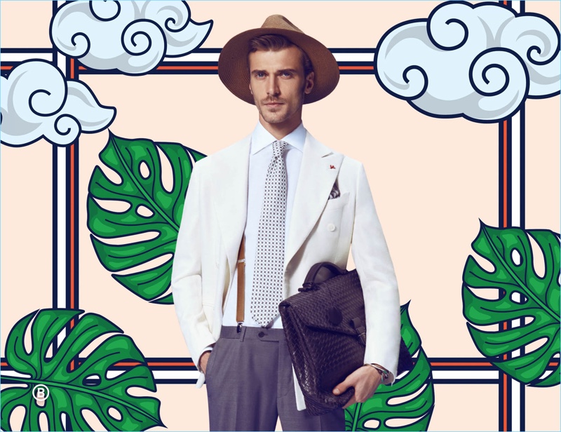 Charming in a sharp look by ISAIA, Clément Chabernaud accessorizes with a Bottega Veneta bag and Borsalino hat.