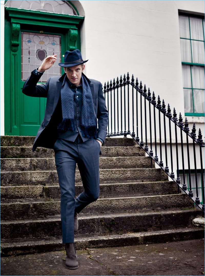 Stepping outdoors, Dan Stevens wears a Burberry suit with a Dolce & Gabbana shirt and John Varvatos boots. Stevens also sports a Stetson hat and Michelsons scarf.