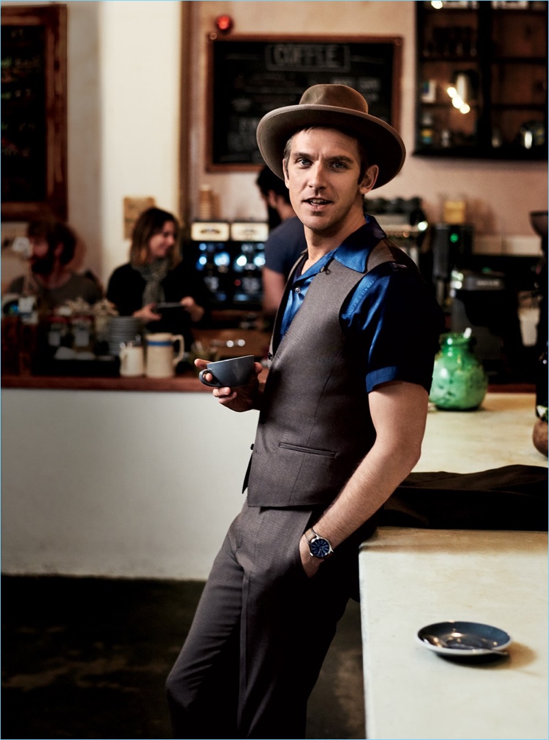 Enjoying a warm beverage at The Fumbally in Dublin, Dan Stevens wears a HUGO Hugo Boss suit with a Visvim shirt, Stetson hat, and Timex watch.