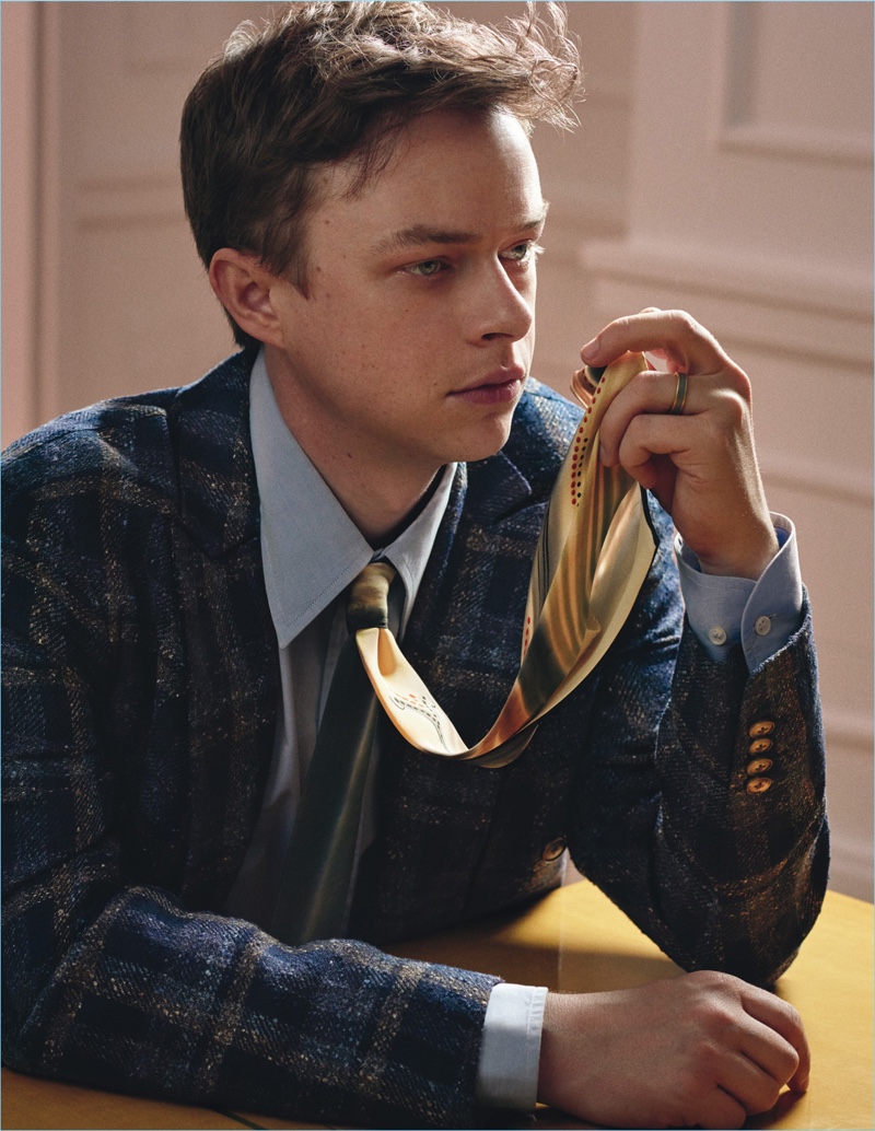 Sitting for a photo, Dane DeHaan dons a check Boglioli blazer with a Giorgio Armani shirt and vintage tie.