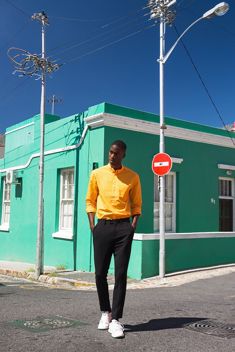 Gauderic wears orange shirt Hugo Boss, trousers Paul Smith, and shoes Prince.