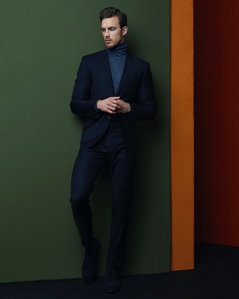 Christian wears suit Acne Studios, turtleneck Thom Browne, and shoes Paul Smith.