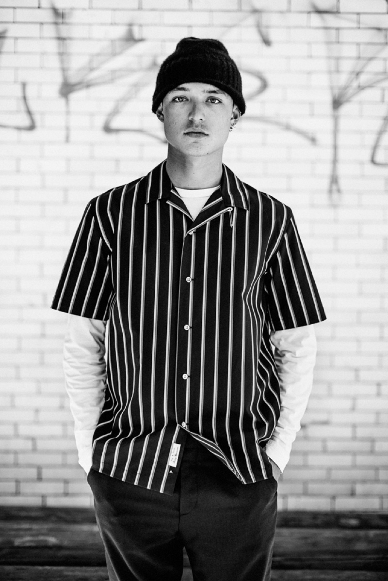 Kaleb wears striped shirt Rag & Bone, long-sleeve tee Schiesser, trousers A.P.C., and knit beanie Hugo Boss.