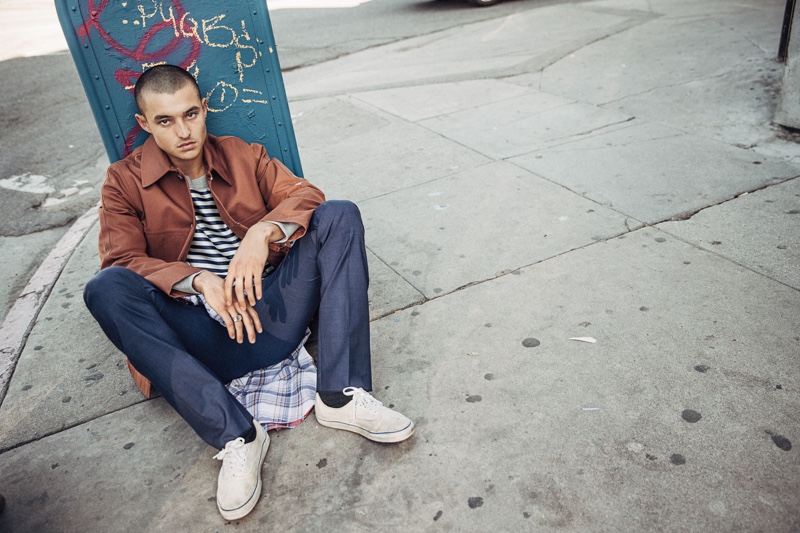 Kaleb wears striped sweatshirt Burberry, leather jacket A.P.C., button-down shirt N°21, trousers Éditions MR, socks Richer Poorer, and shoes Vans.