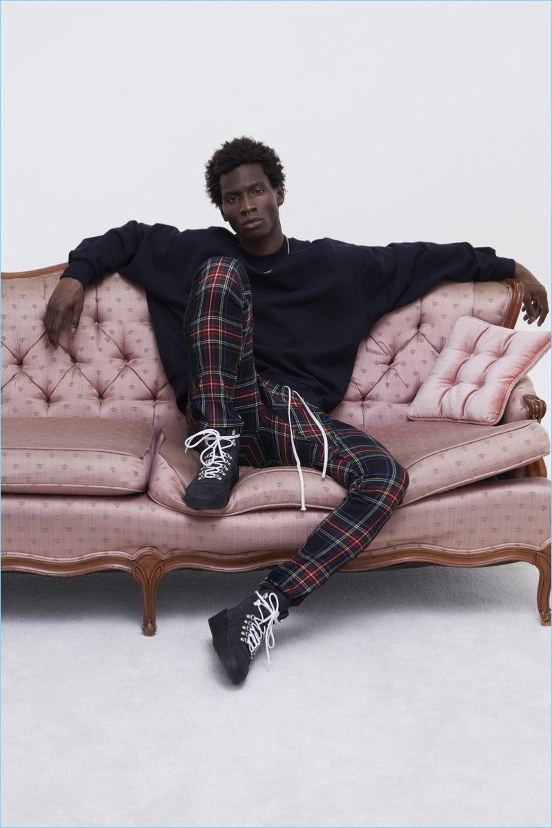 Lounging, Adonis Bosso sports plaid pants and a sweatshirt with boots from Fear of God's fall-winter 2017 collection.