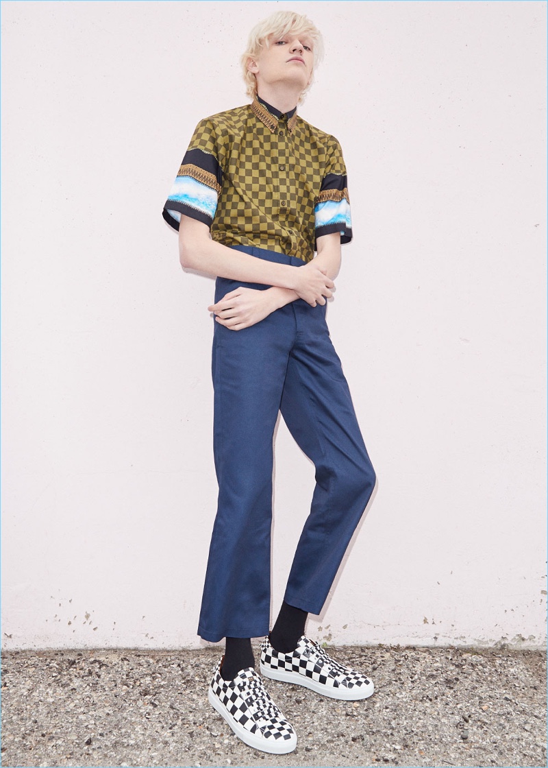 Turner Barbur wears a Givenchy printed short-sleeve shirt $895 with Martine Rose kick flare trousers $666. The bleached blond model also sports Givenchy leather urban street low sneakers $550.