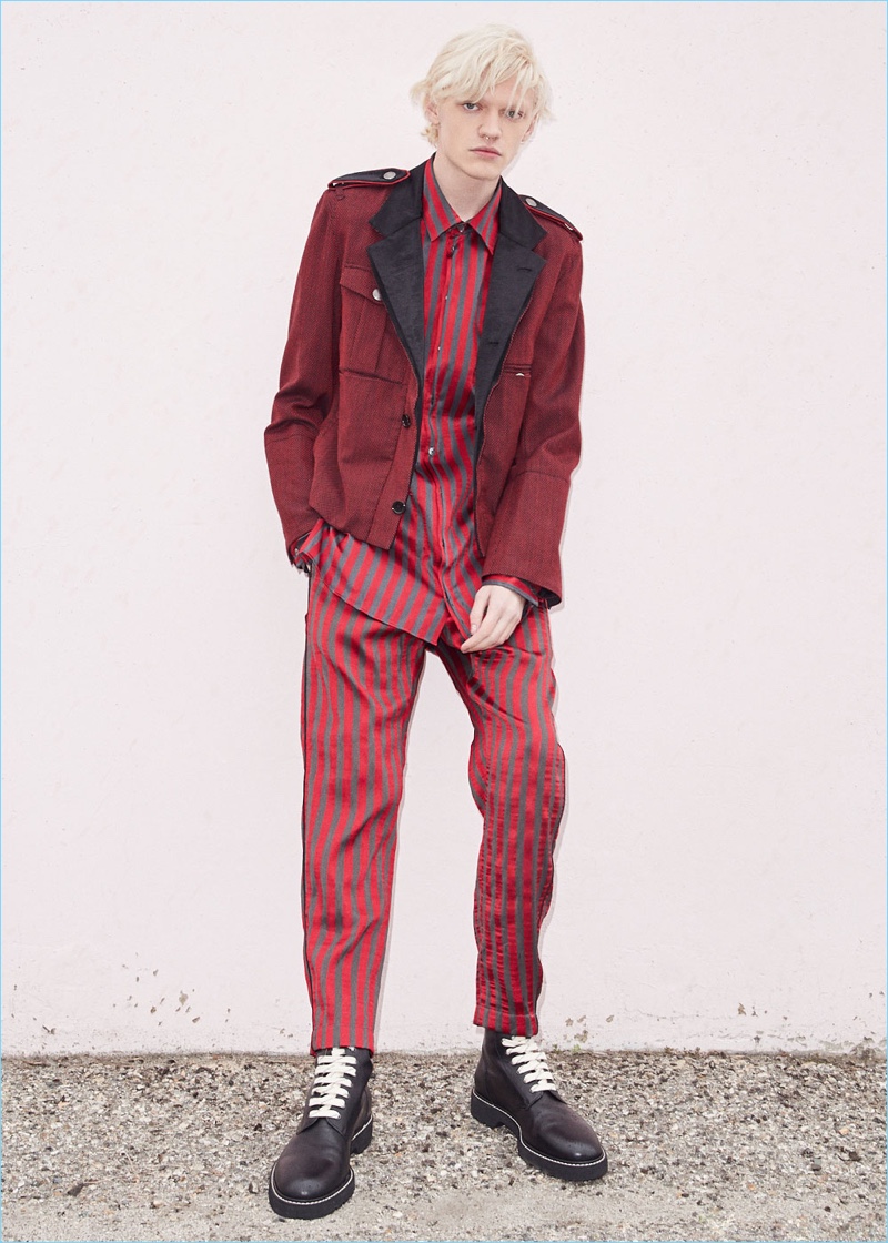 Embracing a monochromatic flair, Turner Barbur wears an Ann Demeulemeester blouson and Maison Margiela combat boots. Turner also dons a red and grey striped shirt with trousers by Ann Demeulemeester.