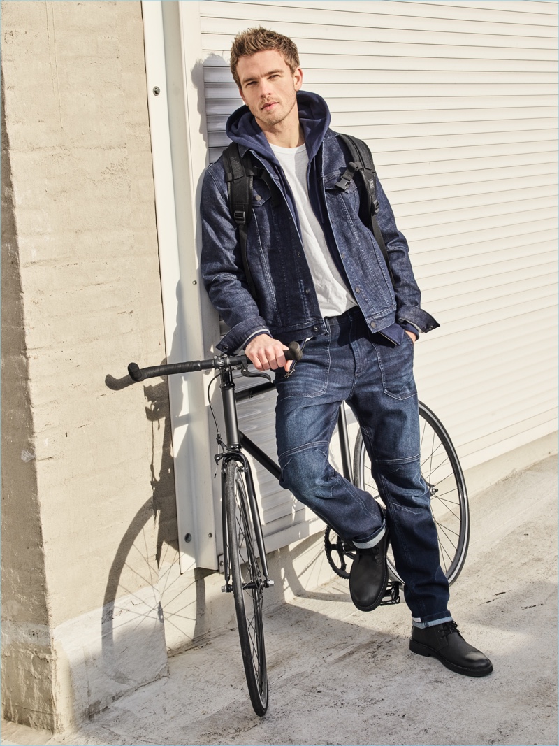 A casual vision, Benjamin Eidem wears a denim jacket and distressed jeans, layered with an essential hoodie.