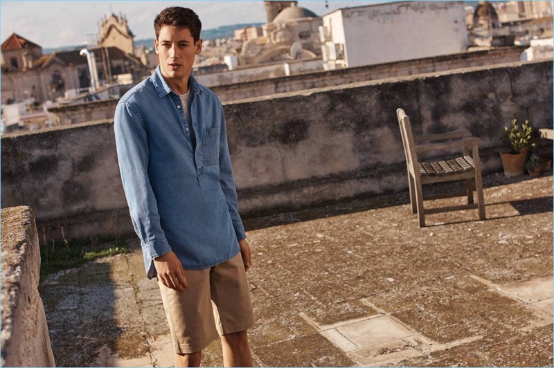 Ready for summer with H&M, Nicolas Ripoll wears a t-shirt, denim popover shirt, and shorts.