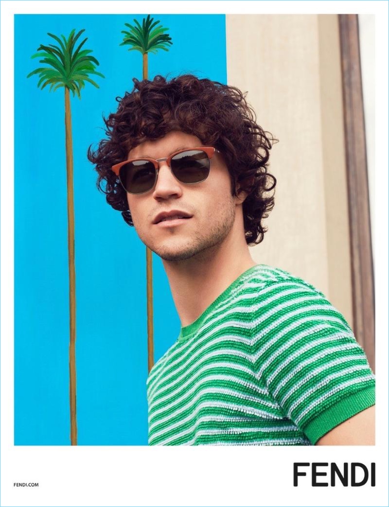 Going casual for Fendi's spring-summer 2017 campaign, Miles McMillan wears a green cotton sweater t-shirt $600 and leather QBIC sunglasses $625.