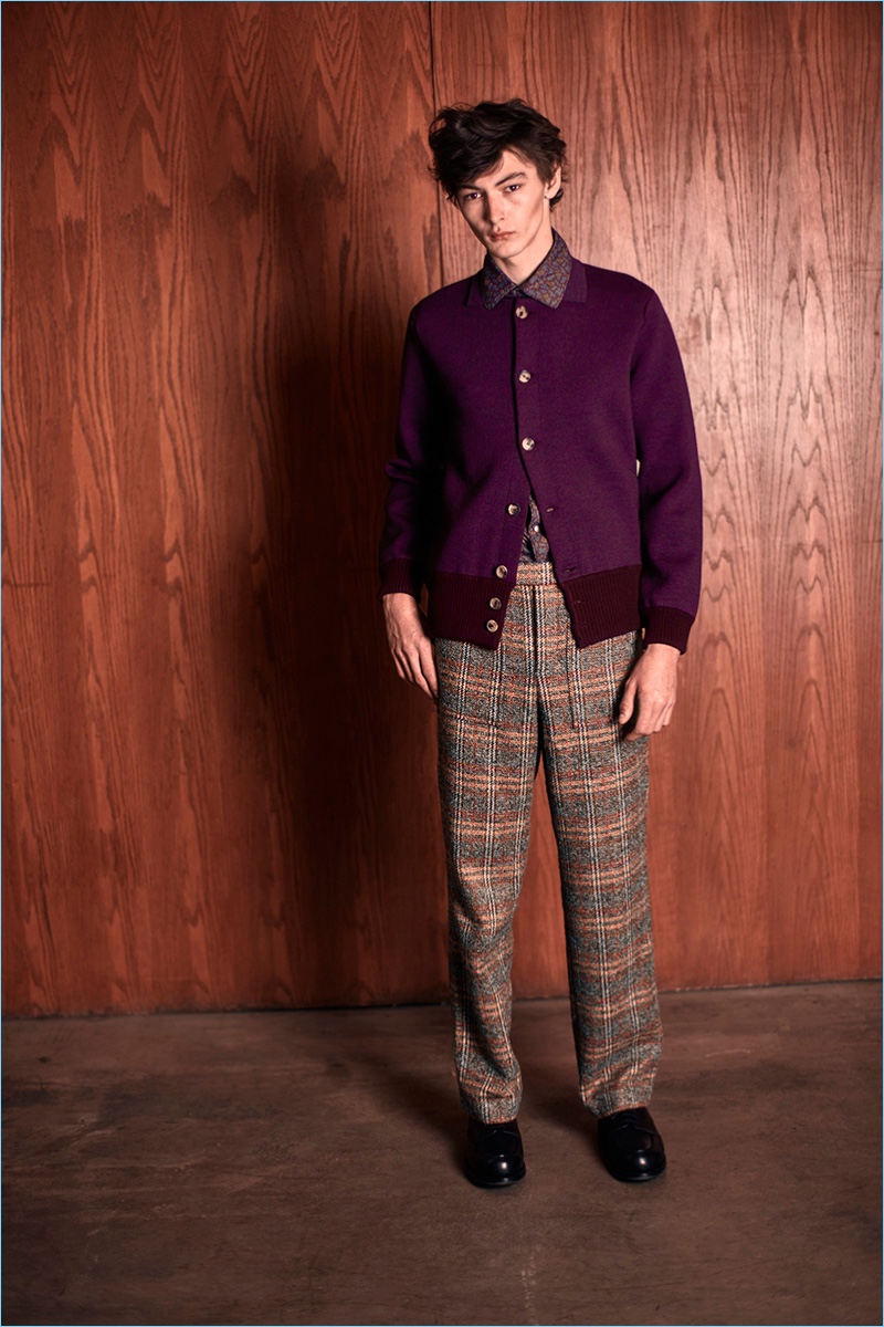 Smart style is front and center with a cardigan, printed shirt, and check trousers by Orley.