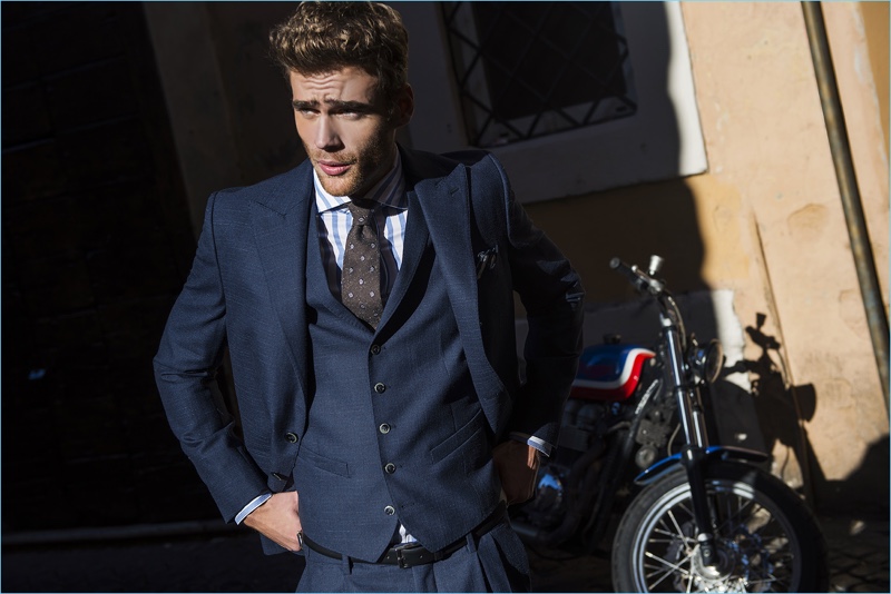 Connecting with Paul Taylor, George Alsford wears a dashing three-piece navy suit.