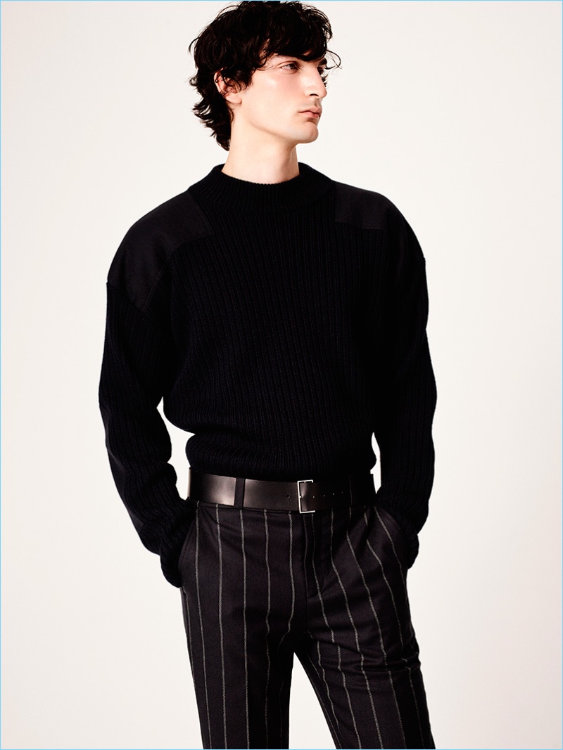 Model Luca Lemaire dons a sculpted sweater with pinstripe trousers from Sandro's fall-winter 2017 men's collection.