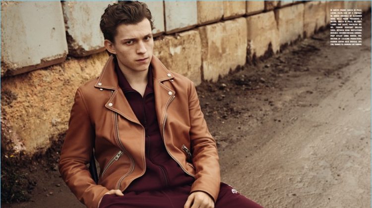 Appearing in a photo shoot for L'Uomo Vogue, Tom Holland wears a brown Loewe leather jacket with a jumpsuit from Adidas Originals by Alexander Wang.